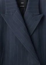 Blazer de corte recto y diseño de raya diplomática, con cuello de solapa con muesca, cierre frontal de doble botonadura y mangas largas con puños abotonados. Cuenta con forro interior y dos bolsillos de solapa en la parte frontal.