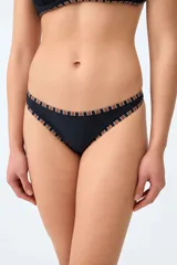Bombacha de bikini tipo vedetina de color negro con ribetes estampados a cuadros en tonos marrones y blancos en los bordes.