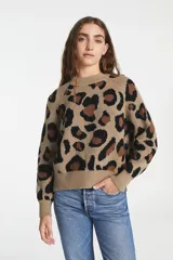Sweater de punto con cuello redondo y diseño de estampado animal print en tonos marrones y negros. Presenta mangas largas con puños acanalados y un corte holgado.