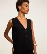 Chaleco Marfinno de corte recto y largo, confeccionado en tricot. Presenta cuello en V, cierre frontal con botones y diseño liso sin estampados.