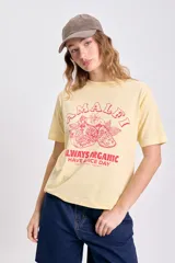 Remera amarilla de manga corta con estampa de limones y texto en color rojo.
