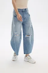 Pantalón de jean celeste con roturas, pinzas y corte barrel.