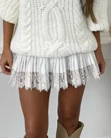 Minifalda plisada de color blanco con detalle de encaje en el ruedo.