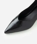 Zapato tipo scarpin de poliuretano color negro, con punta fina, escote en V y taco bajo tipo kitten heel.