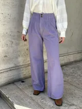 Pantalón wide leg de jean color lila, con tiro alto, pinzas en la pretina y elástico en la cintura.