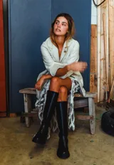 Botas de caña alta hasta la rodilla, confeccionadas en cuero, con suela track de goma y cierre frontal con cremallera.