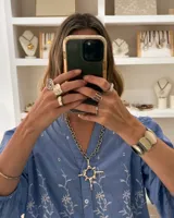 Collar plateado con cadena gruesa y dije grande con forma de sol.