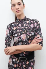 Polera negra con estampado floral estilo búlgaro, cuello alto y mangas 3/4.