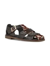 Sandalias de cuero marrón con diseño tipo franciscanas, combinadas con apliques de pelo con estampado animal print tipo vaca, hebilla metálica dorada de ajuste en el tobillo y suela plana.