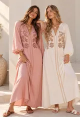 Vestido largo beige con detalles bordados florales en el pecho y mangas abullonadas.
