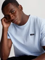 Remera Calvin Klein de punto de algodón regenerativo, color celeste, con corte regular, cuello redondo y mangas cortas. Presenta una lengüeta con el logo de Calvin Klein en el pecho.