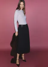 Falda midi plisada negra con doble cinturón de cuero sintético con hebillas plateadas.