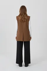 Chaleco sastrero color marrón, sin mangas, con solapas clásicas y bolsillos laterales con solapa.