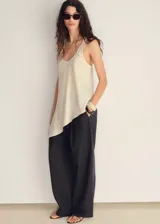 Pantalón de vestir de corte recto y tiro medio, confeccionado en tejido mezcla de algodón y lino con estampado de rayas verticales. Cuenta con cierre delantero de cremallera y botón, trabillas para cinturón y dos bolsillos laterales.
