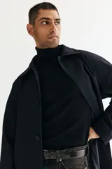 Buzo de punto fino con cuello alto acanalado, manga larga y terminaciones en puños y bajo acanalados. Presenta un corte estándar.