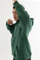 Buzo hoodie verde oscuro con estampa serigráfica frontal de alta definición con una escena urbana en estilo puntillista y logo VERNAL con efecto dorado envejecido. Corte oversize con hombros caídos, capucha doble y bolsillo canguro.