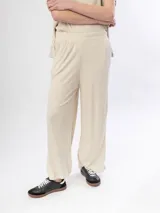 Pantalon de corte recto y holgado, confeccionado en tejido de punto acanalado color beige, con cintura elástica.