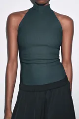 Top negro de cuello halter con cierre de botones en la parte trasera del cuello y espalda descubierta.