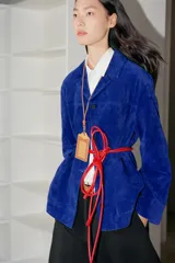 Chaqueta de piel de ante color azul, con cuello de solapa, bolsillos delanteros de plastrón, forro interior y cierre frontal con botones.