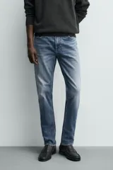 Pantalón de jean corte slim fit, color gris con efecto lavado. Presenta diseño de cinco bolsillos, cierre frontal con cremallera y botón, y tejido elástico.