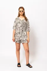 Camisa estampada con cuello clásico, mangas cortas y cierre frontal con botones.