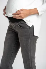 Pantalón de jeans gris oscuro, de corte flare y tiro medio, con ruedo desflecado.