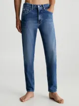 Jeans de algodón elástico con lavado azul medio vintage. Presentan un diseño de cinco bolsillos, bragueta con cremallera y talle medio. El corte es tapered, ajustándose gradualmente hasta la pierna.