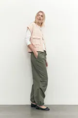 Chaleco de tweed color salmón con diseño a cuadros, sin mangas, con bolsillos frontales y botones perlados.