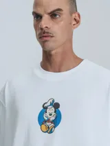 Remera blanca de manga corta con cuello redondo y calce oversize. Presenta un estampado frontal de Mickey Mouse vestido de chef.
