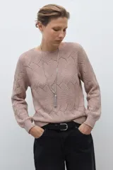 Sweater de punto color beige claro, con escote bote y tejido calado con diseño ondulado. Es de manga larga y corte recto.