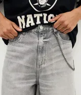 Bermuda de jean estilo baggy con corte recto y holgado, color gris lavado. Presenta detalles de costuras decorativas en el ruedo y diseño de cinco bolsillos.