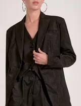 Blazer de mujer color beige, confeccionado en material similar a la gamuza, con solapas anchas, un botón forrado en la parte frontal y bolsillos de ojal.