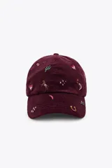 Gorra tipo baseball confeccionada en pana color bordó, con múltiples bordados decorativos de motivos variados como cactus, caballos, corazones y estrellas. Presenta ajuste posterior y visera curva.