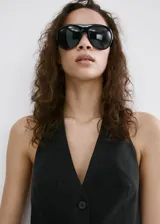 Chaleco negro con cuello en V, cierre frontal con botones y diseño slim.