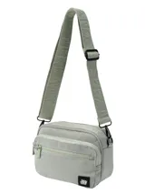 Bandolera compacta de lona color verde claro, con tres compartimentos principales con cierre y correa ajustable con logo grabado. Incluye un parche con el logo de la marca en la parte inferior frontal.