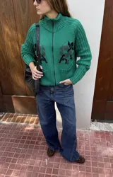 Saco tejido de punto verde con cuello alto y cierre frontal, manga larga y diseño con estampado geométrico localizado en el frente.