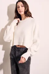 Sweater color crema de tejido de punto, corte crop y mangas abullonadas.