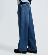Pantalón de jean azul con corte barrel, cintura alta y estructura amplia. Presenta diseño de cinco bolsillos, cierre frontal con botón y trabillas para cinturón.