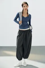 Pantalón de tiro medio y cintura elástica con cordón de ajuste, bolsillos laterales y bajo abullonado con puños elásticos. Confeccionado en poliamida.