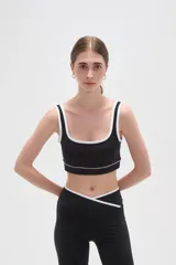 Top deportivo negro con detalles de ribete blanco en el escote y breteles. Presenta un diseño de corte cuadrado y ajuste al cuerpo.