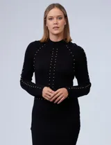 Vestido midi tejido de punto color negro, con cuello alto y mangas largas. Apliques de perlas doradas en el frente y la espalda.
