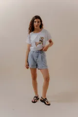 Remera blanca de algodón con ilustración de un perro salchicha con pañuelo animal print y gafas de sol.