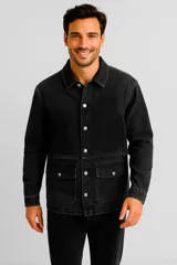 Campera de jean color negro con cierre frontal de botones metálicos, cuello clásico y dos bolsillos frontales con solapa.