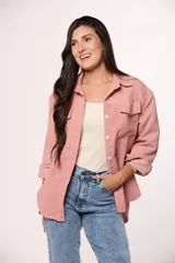 Camisa de pana fina color beige, con cuello clásico, cierre frontal de botones y dos bolsillos con solapa en el pecho.