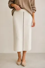Falda midi de punto color beige, de tiro alto con cintura elástica, silueta recta y una costura vertical marrón en el centro frontal.