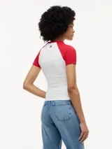 Remera de corte slim con mangas raglán a contraste en color rojo. Presenta estampado frontal con logo de Cadillac en fuente script y detalles de la colaboración con Formula 1 Team. Confeccionada en algodón elástico con cuello redondo.