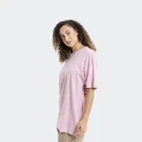 Remera de corte oversize color gris, con cuello redondo y mangas cortas. Presenta un estampado pequeño en el centro del pecho con motivos florales y de frutas en color rosado.