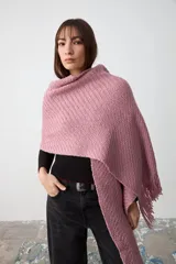Chal de tejido de punto con textura acanalada, color rosa, con terminación de flecos en los extremos y etiqueta de cuero con logo de la marca.