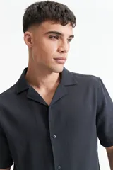 Camisa de manga corta color crema con textura, cuello clásico y calce regular.