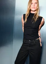 Jeans de tiro bajo y corte wide leg, confeccionados en tejido de algodón estilo denim. Presentan diseño de cinco bolsillos, cierre de cremallera y botón, y trabillas en la cintura.